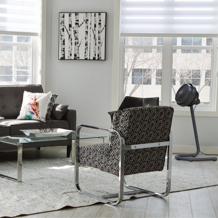 Modern living room with a patterned armchair, coffee table, and abstract art on the wall.