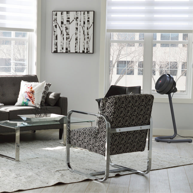Modern living room with a patterned armchair, coffee table, and abstract art on the wall.