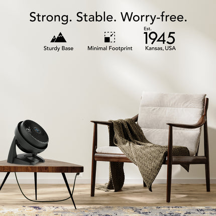 Modern chair with a blanket and a small table with a fan in a room setting, with text about product features and establishment year.
