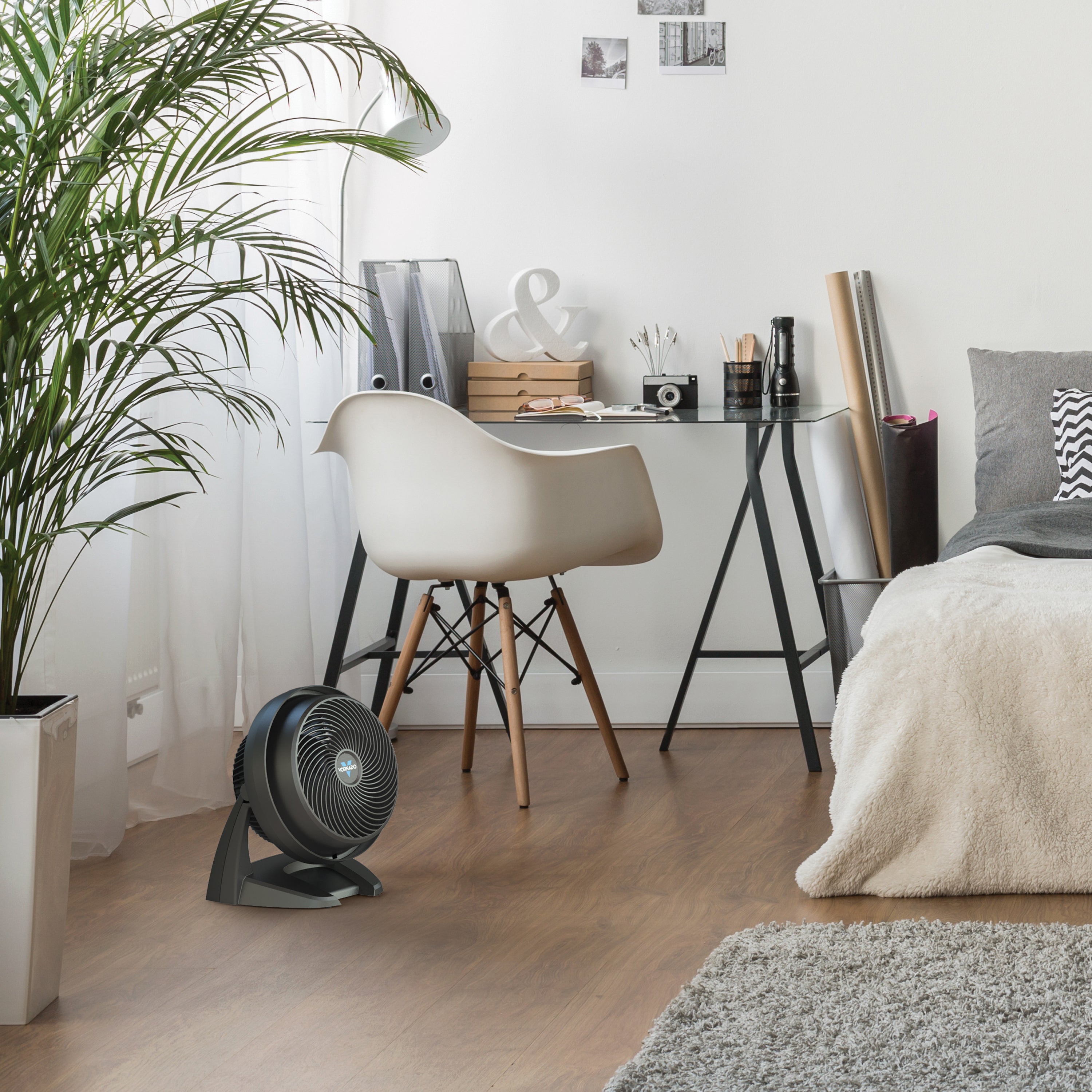 Modern home office with a desk, chair, and floor fan.
