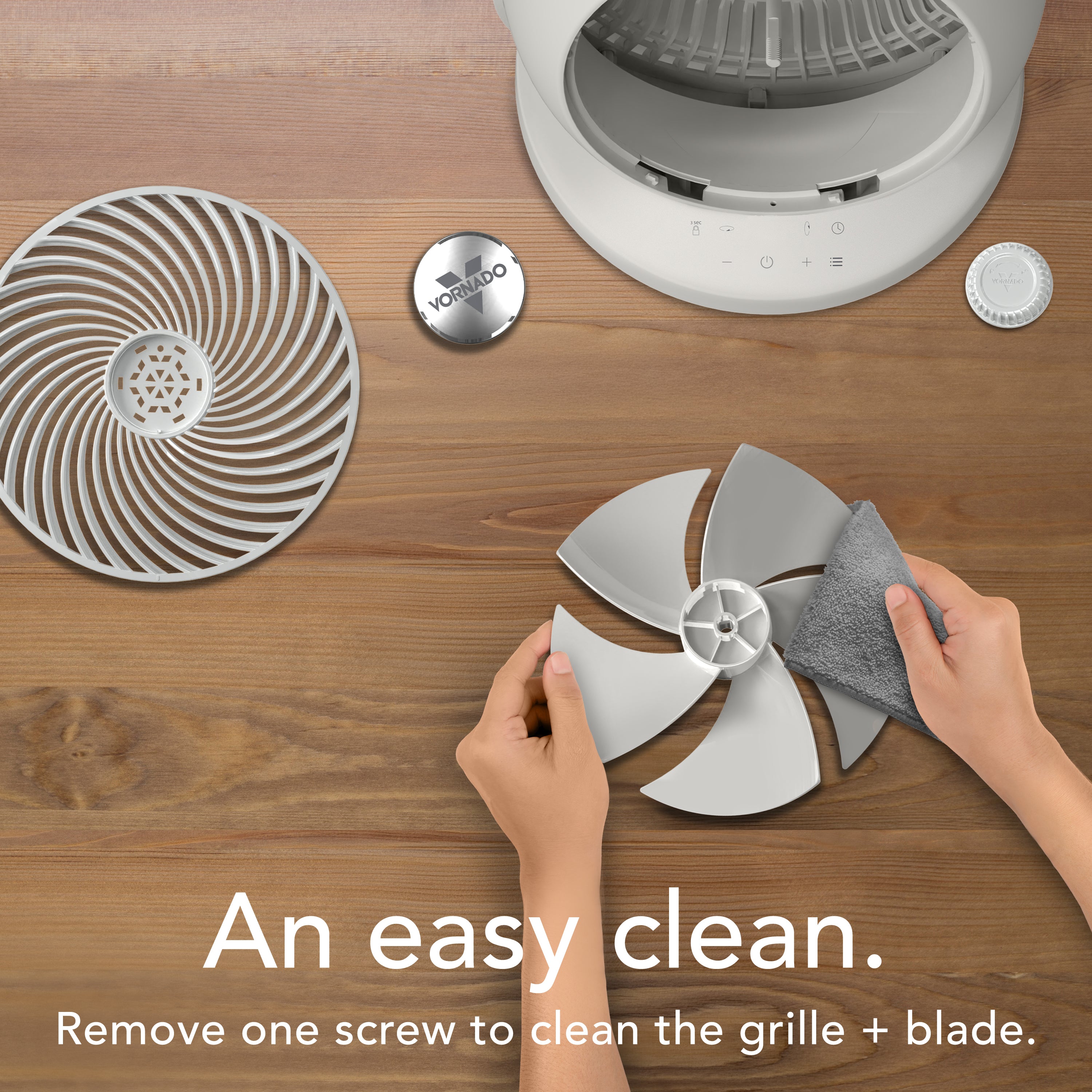 Cleaning a fan grille with a scrubber on a wooden surface, featuring text about easy cleaning.