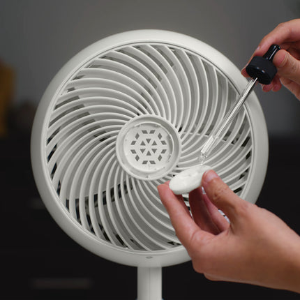 Person cleaning a white fan with a brush and white cleaning paste.