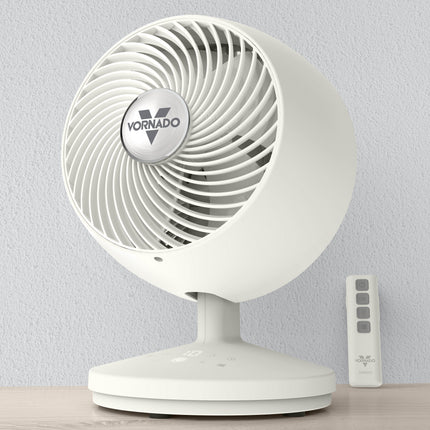 White Vornado fan with remote control on a light gray background