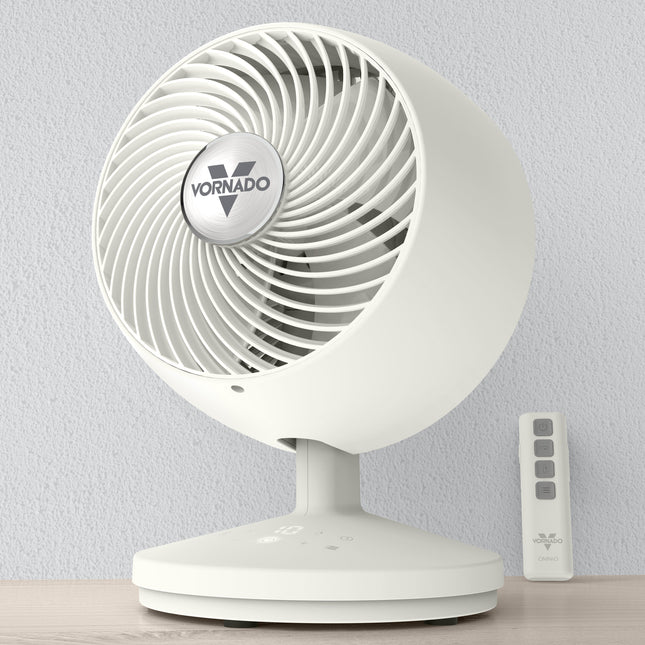White Vornado fan with remote control on a light gray background