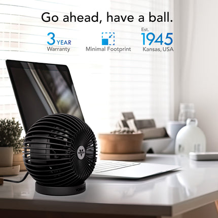 Black fan on a desk with a laptop, minimal footprint highlighted, and brand details.