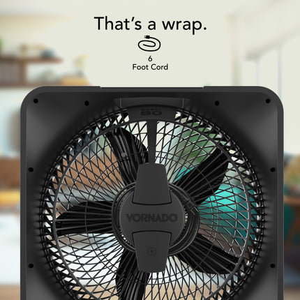 Black Vornado fan with a blurred indoor background