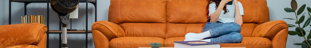 Woman sitting on orange couch as 6803 OSC is to her right in the room.