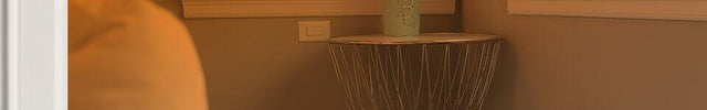 Part of a bedroom seen through an open door with an orange gradient to show whole room heat circulation. AVH10 is on the floor.