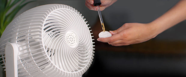 Person putting essential oil on a scent pad for EOS 9S.
