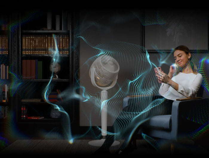 A woman in sitting in a chair reading on her phone with EOS 9S next to her. Blue lines are around her to indicate omniwave airflow.