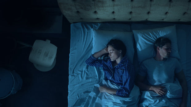 Top view of couple asleep in bed as EOS S is to the side in sleep mode.