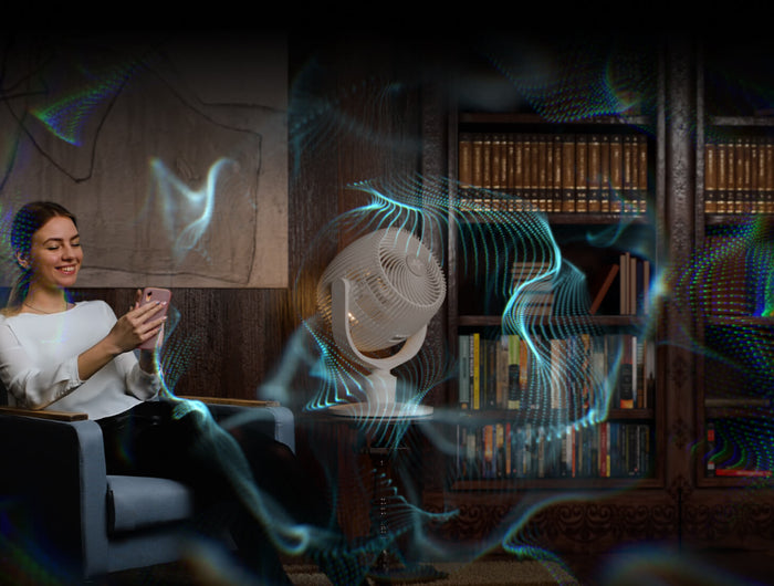 woman sitting in chair. on the table next to her is eos 9 in omniwave mode There are blue wavy lines overlayed to indicated cool airflow