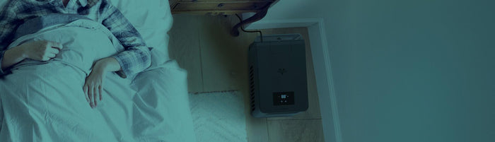 Top view of EV3 on the floor of a bedroom as a person sleeps in bed.