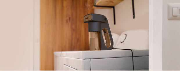 Vornado Express handheld garment steamer on top of a dryer.