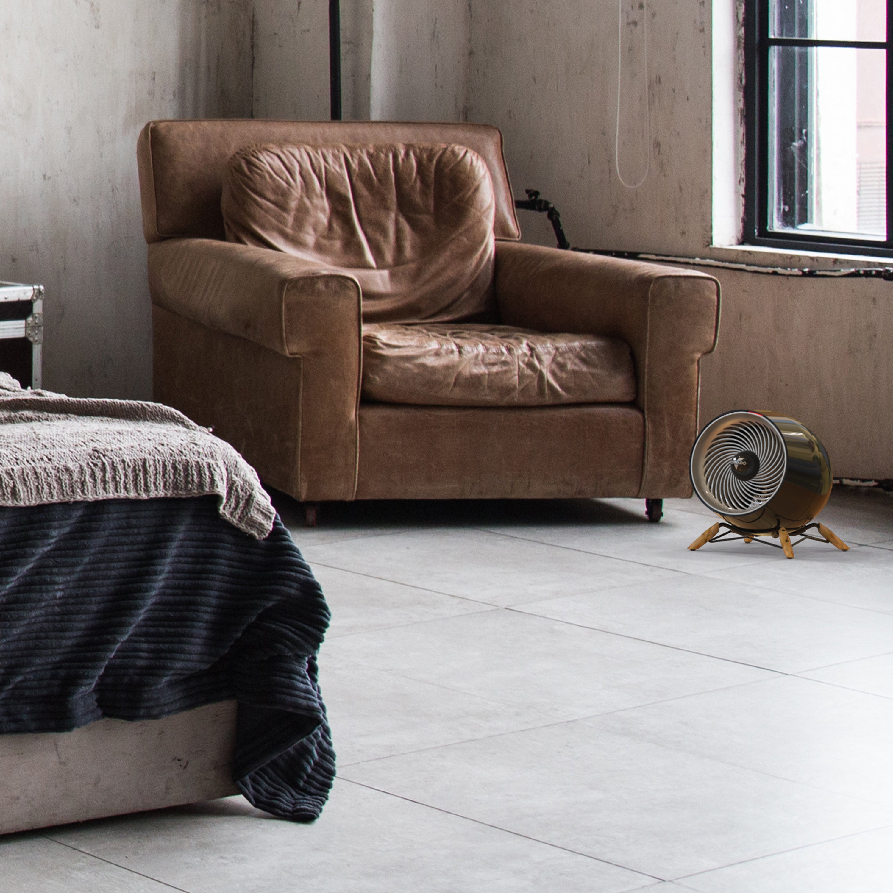 glide heat in a modern bedroom in front of a leather chair and facing a bed. Natural light fills the room from a window behind the heater.