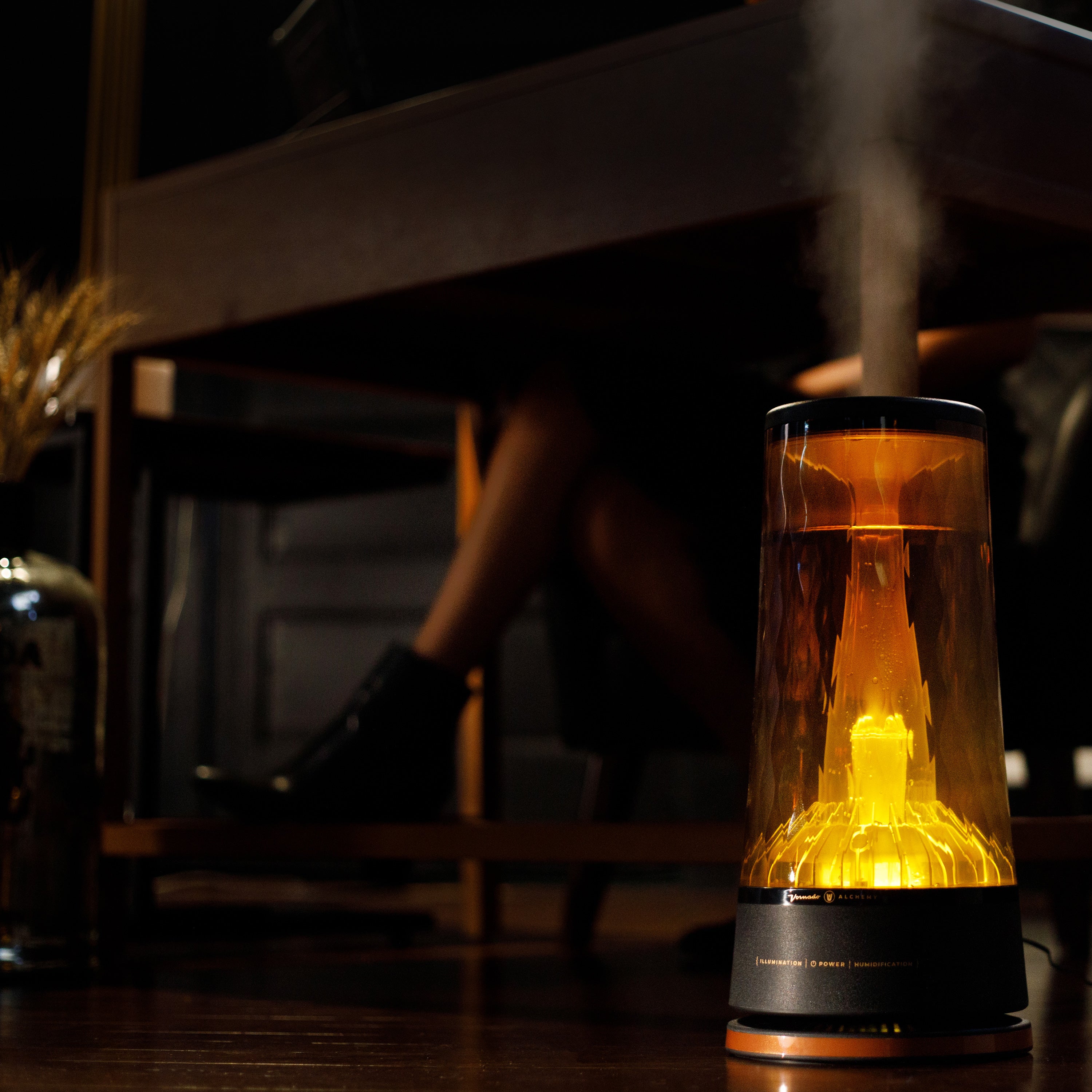 Lucerna 2 humidifier with ambient light illuminating in a dark room with mist coming out of the top