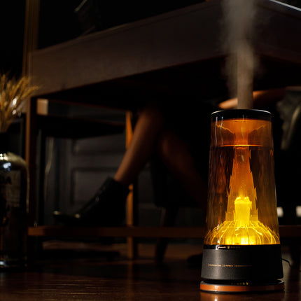 Lucerna 2 humidifier with ambient light illuminating in a dark room with mist coming out of the top