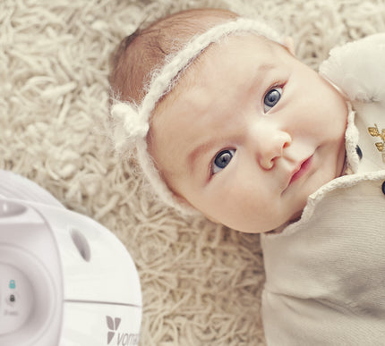 top of sensa heater next to a baby laying on carpet flooring