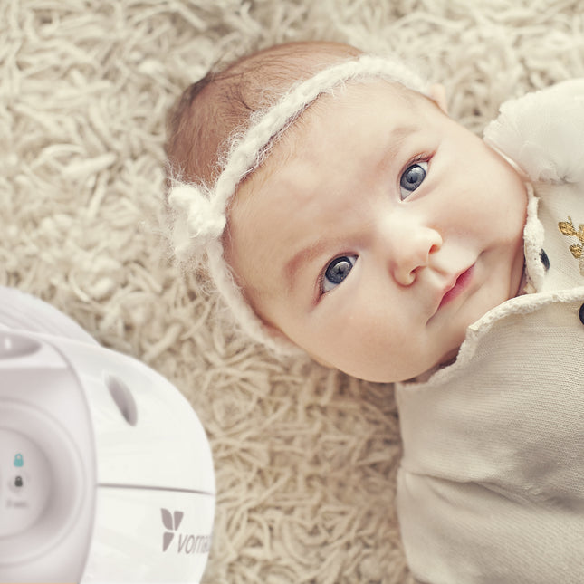 top of sensa heater next to a baby laying on carpet flooring