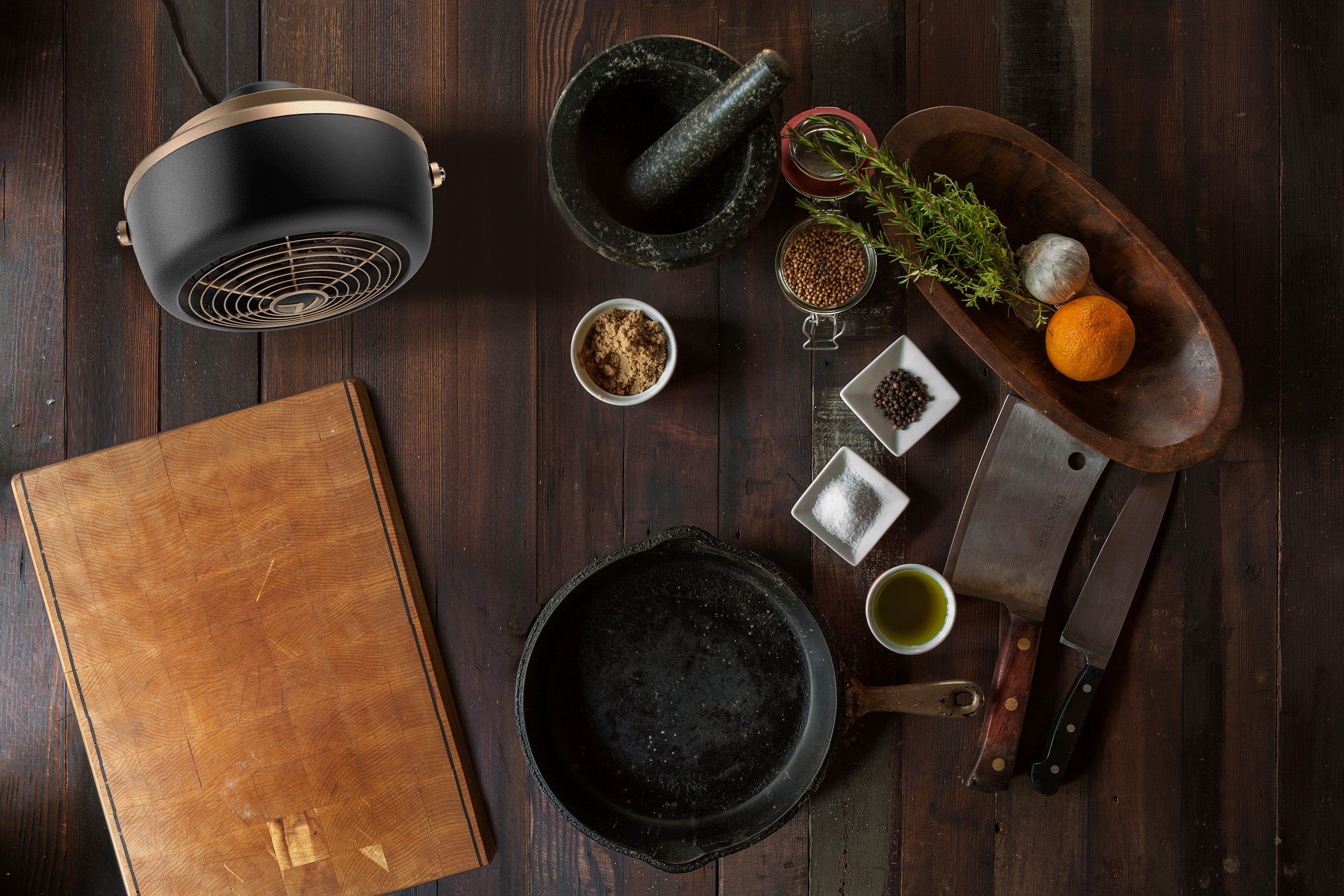 VFan Petite Alchemy next to a cutting board and cooking supplies.