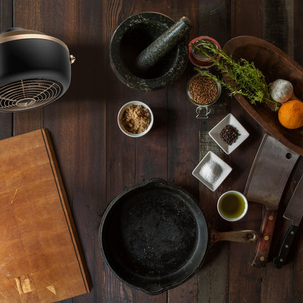 VFan Petite Alchemy next to a cutting board and cooking supplies.