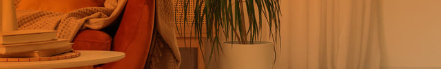 Part of a living room seen through an open door with an orange gradient to show whole room heat circulation. VH240 is on the floor near a couch.