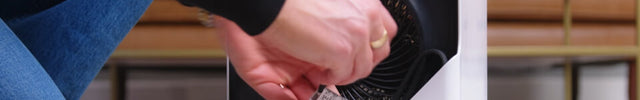 A woman wrapping Velocity Cube 5 OSC's cord and tucking it away.