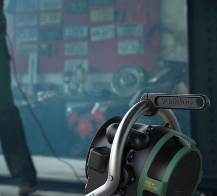 velocity HD in a garage with tools and licenses plates hung up on the wall in front of it barely visible. A man with a tool is working in front of the heater