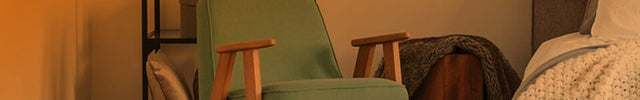 Velocity 5 heater in a bedroom near a chair. There is an orange gradient to show whole room heat circulation. 