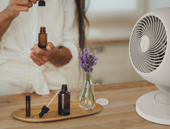 Person holding a dropper to add essential oil to a Vora 8 scent pad. 