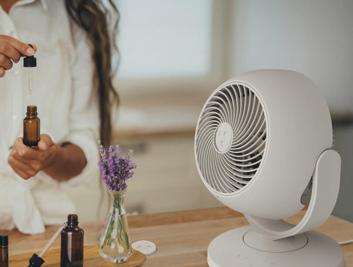 Person holding a dropper to add essential oil to a Vora 8 scent pad. 