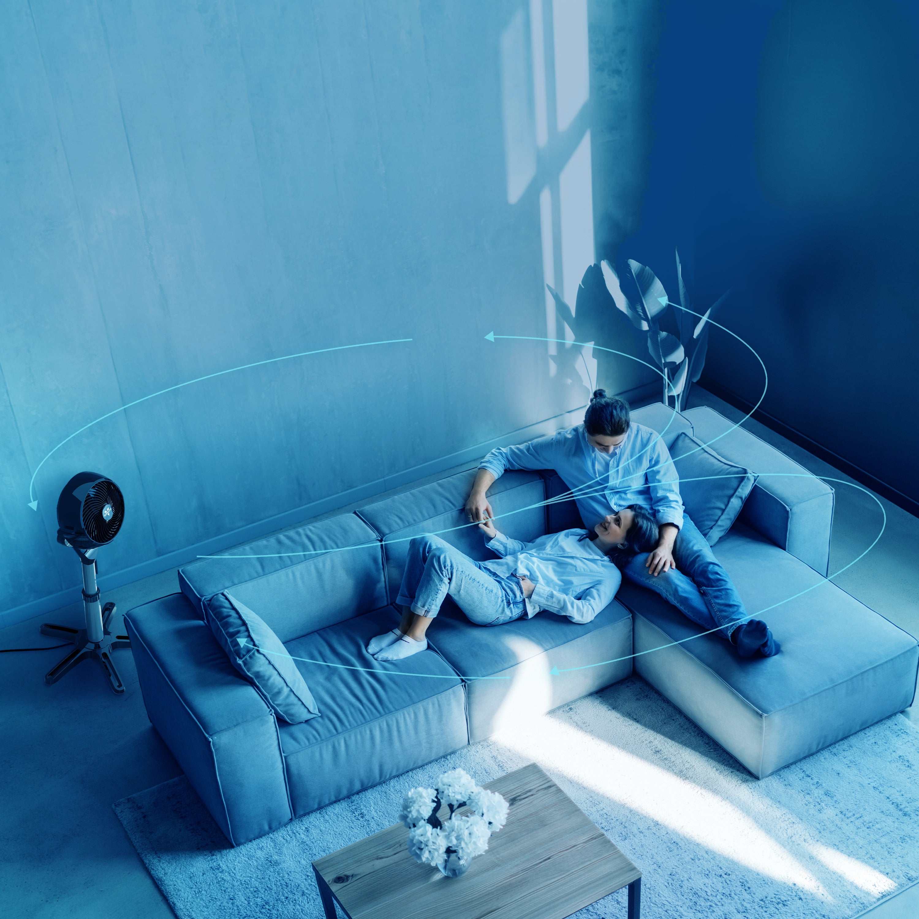 Vornado 6803 OSC pedestal air circulator delivering whole-room air circulation, illustrated with airflow moving throughout a living room.