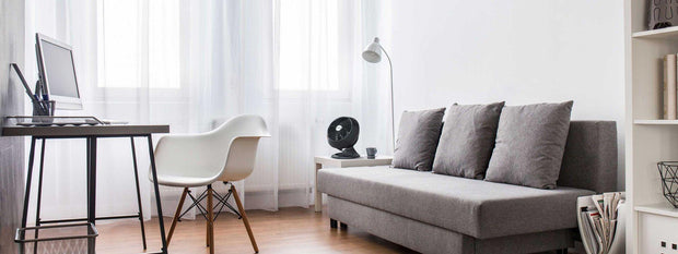 Circulator on side table next to loveseat in home office.