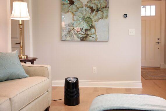 Lifestyle of a black Ultra3 ultrasonic humidifier in a living room by a couch