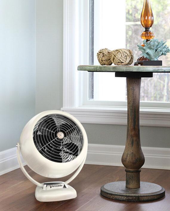Lifestyle of a white vintage VFAN SR air circulator in the corner near a window and wooden table