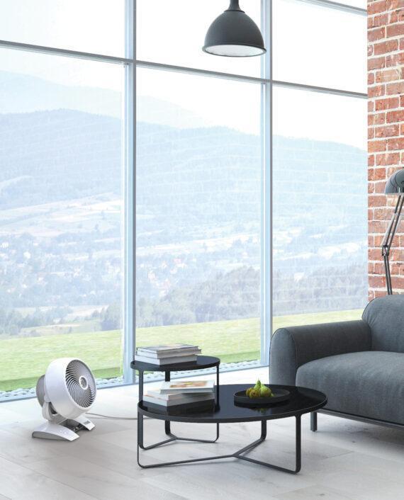 White 6303 DC Medium-sized Air Circulator by a circular coffee table and large window.