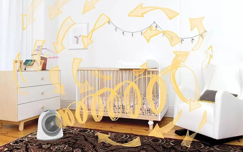 Lifestyle of Sensa Sensa Sensing nursery heater in a nursery by a crib. Pale yellow arrows are drawn throughout the room to indicate circulation pattern