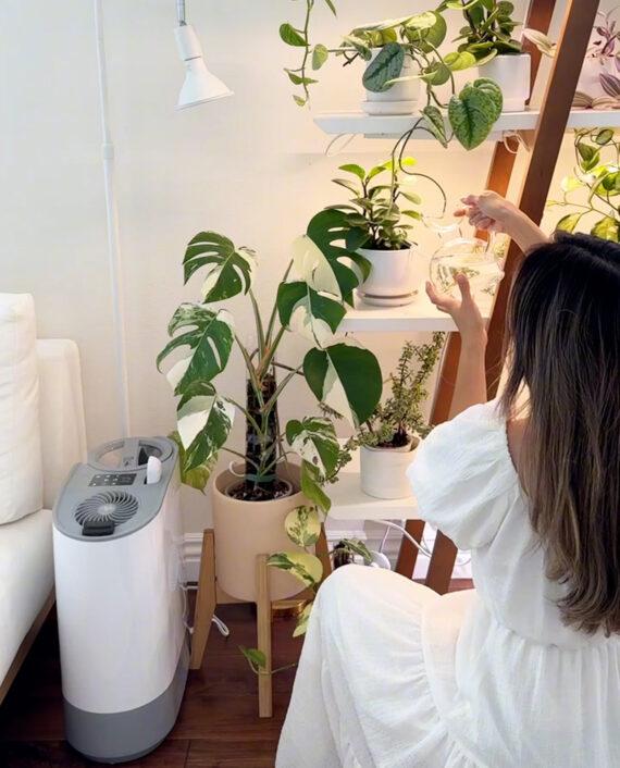 UH200 runs next to a plant shelf while a woman waters the plants