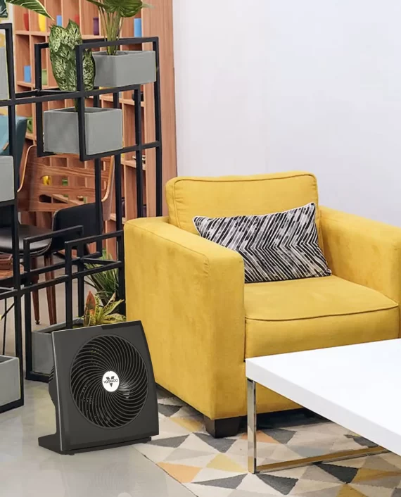 673T Tilting Whole Room Air Circulating Panel Fan in a living room on the floor next to a yellow chair