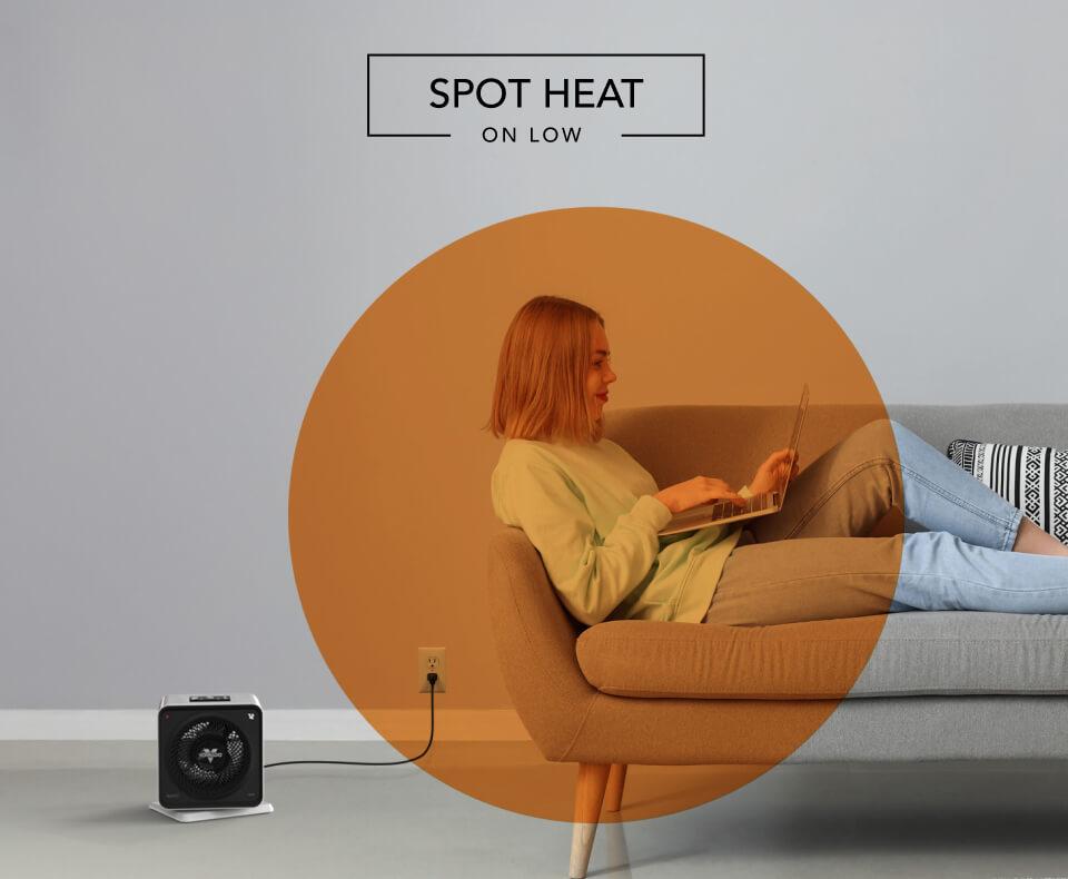 Woman laying on a couch with the Velocity Cube 5S heater on the floor. There is an orange circle overlay on her to indicate spot heat on low.