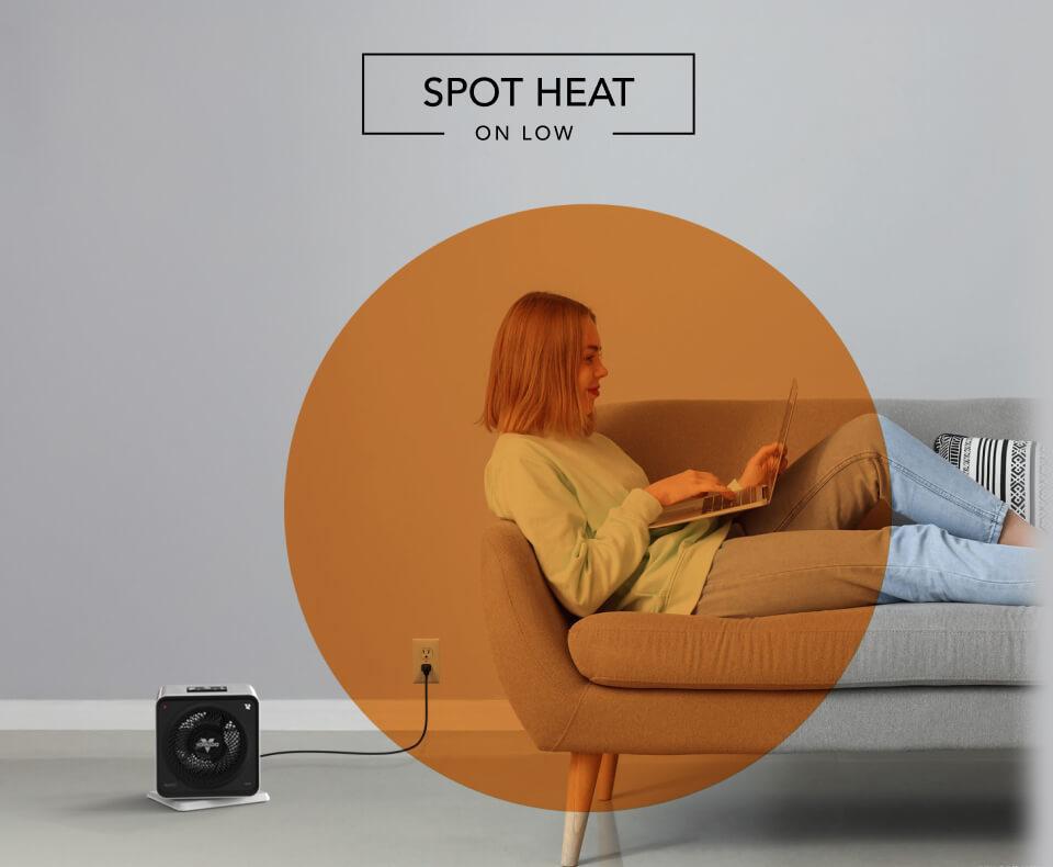 Woman laying on a couch with the Velocity Cube 5S heater on the floor. There is an orange circle overlay on her to indicate spot heat on low.